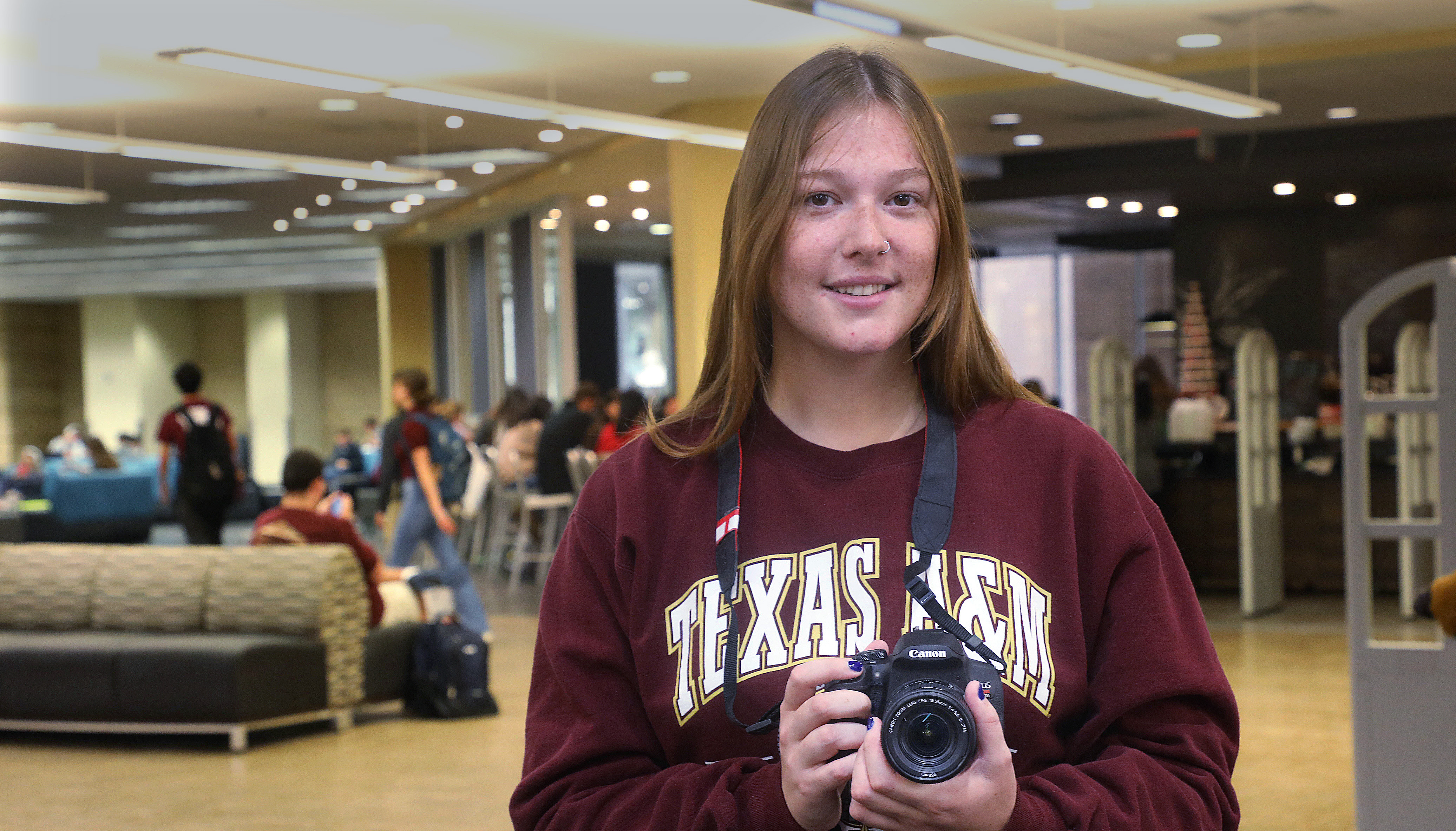 Aggie student holding camera